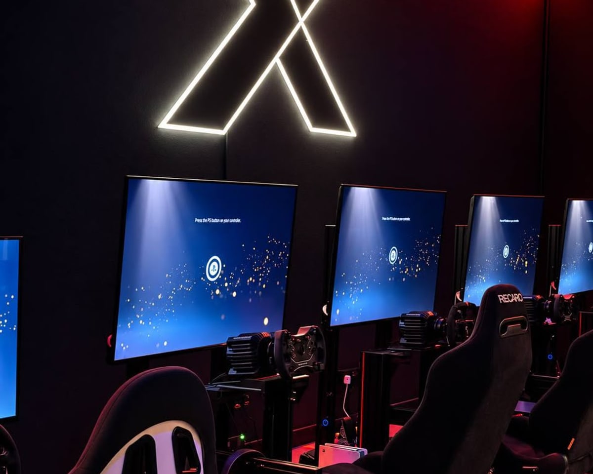 Sim racing stations beneath Xerom’s illuminated X