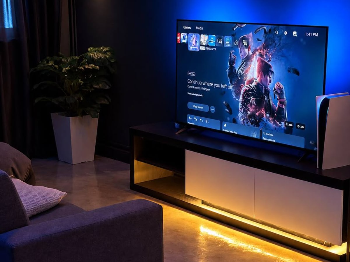 PS5 lounge with a sofa, screen and console at Xerom